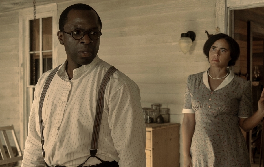 A man and woman standing in front of a house.