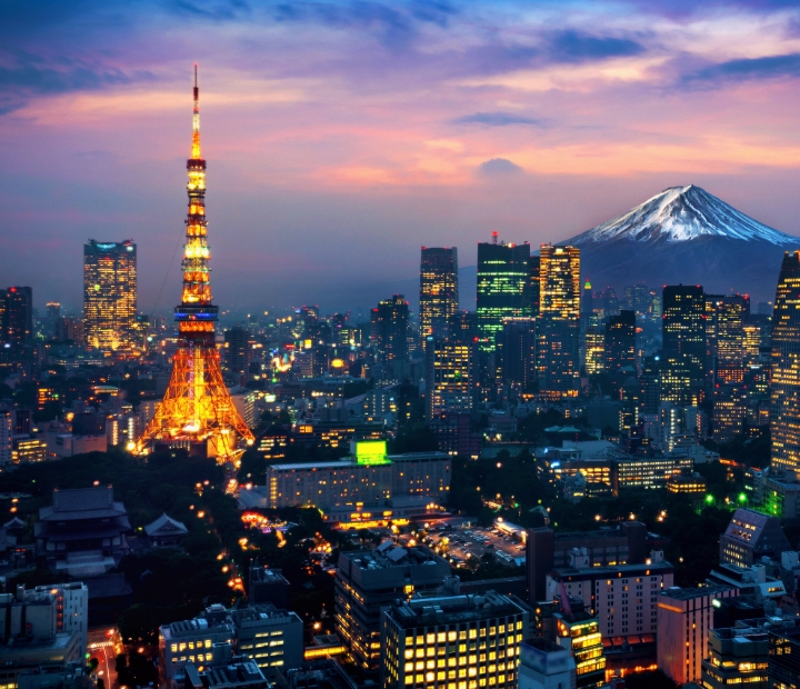 The city of tokyo at dusk with mt fuji in the background.