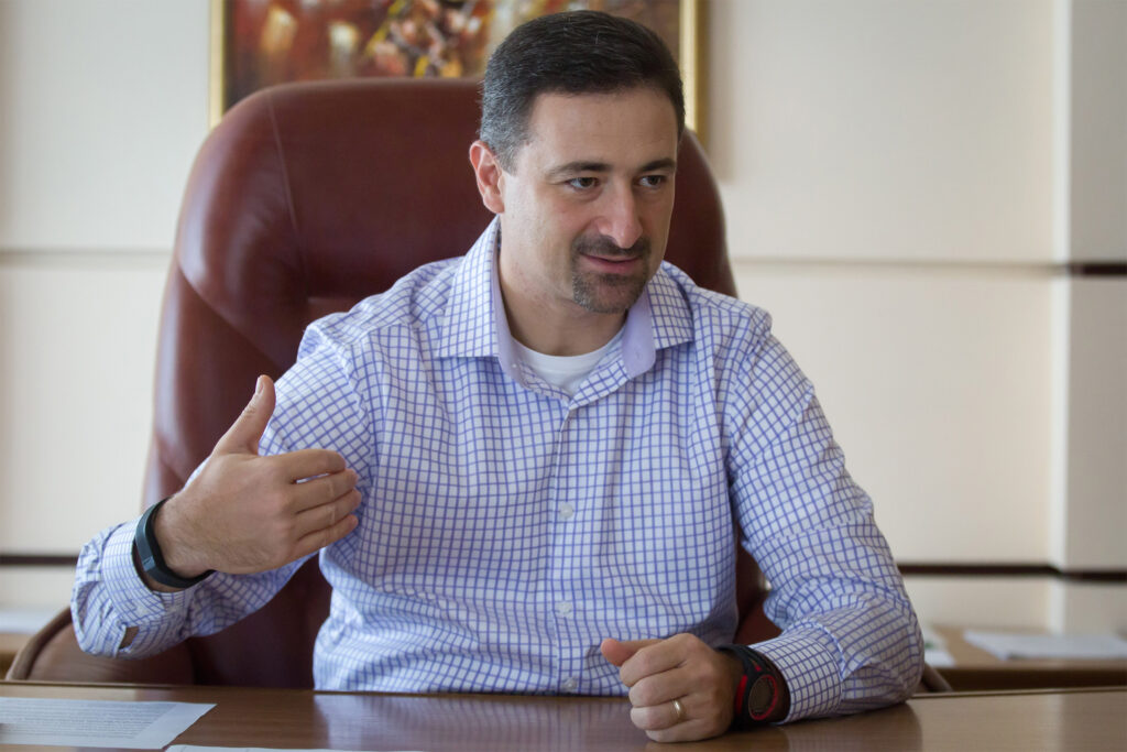 A man sitting at a desk giving a thumbs up.