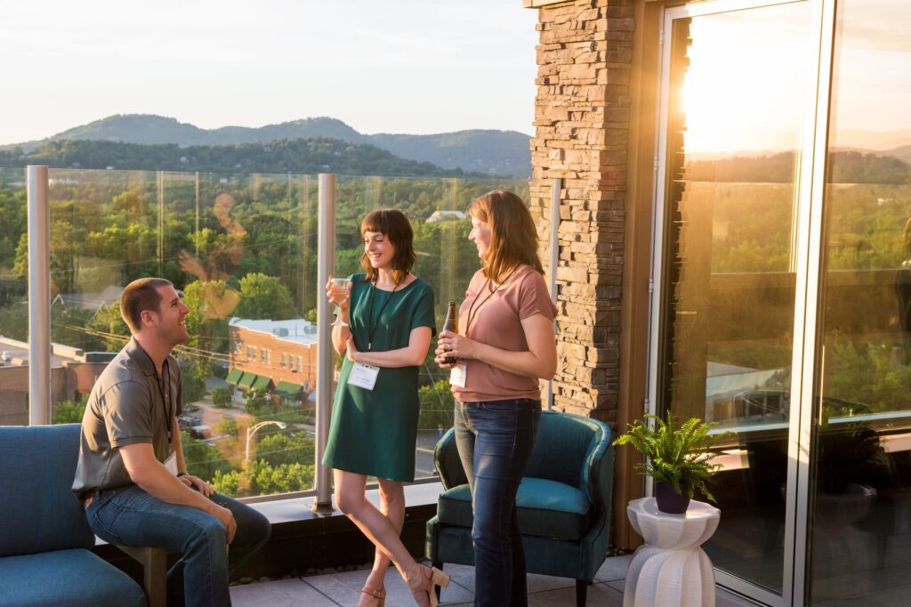A group of people standing on a balcony overlooking a mountain.