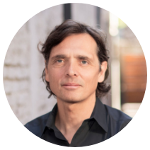 A man with long hair in a black shirt.